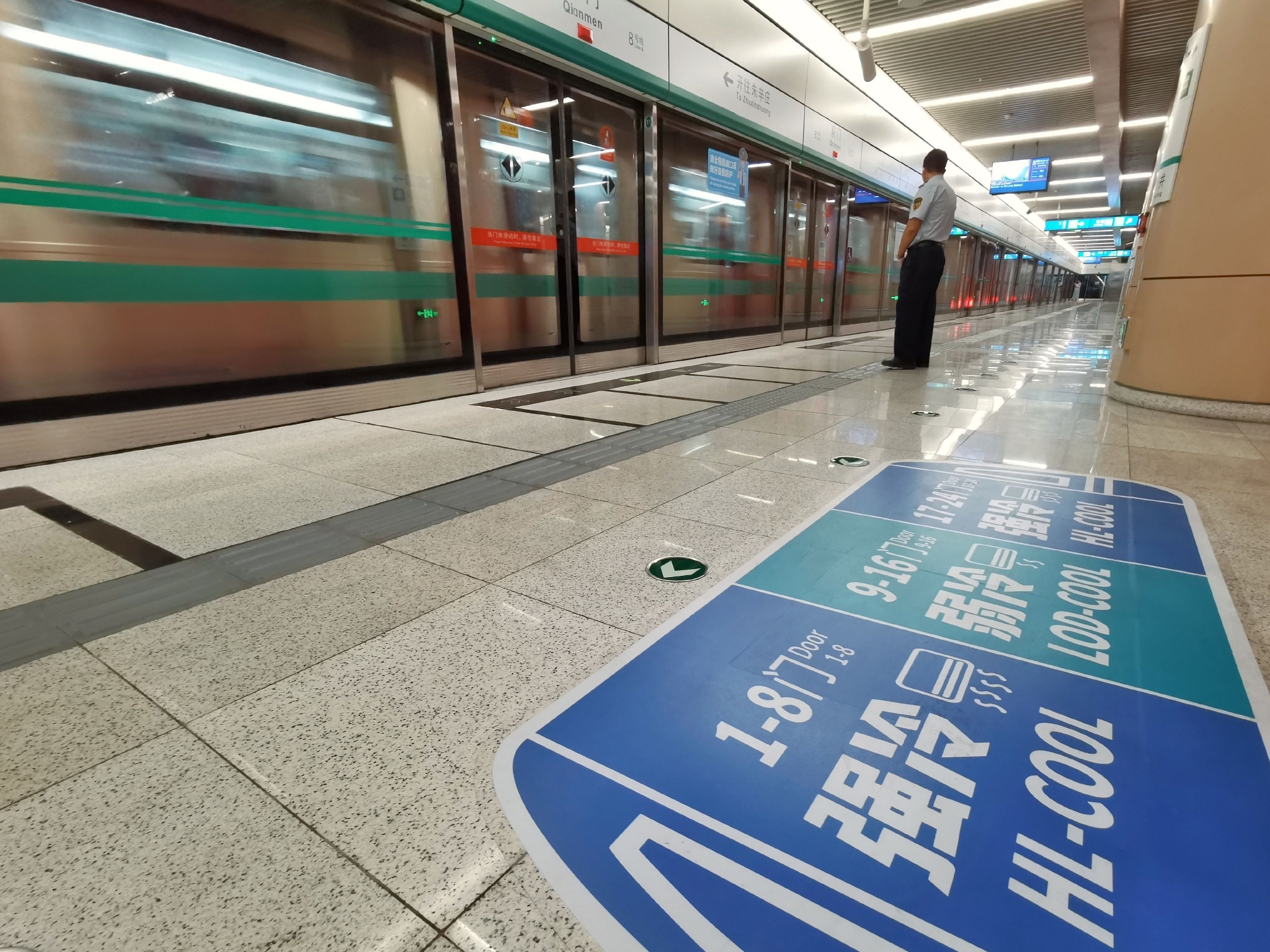 8号线前门站,站台地面贴有"强冷弱冷车厢"引导标志.