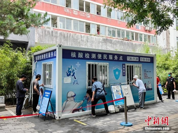 资料图：民众在北京市朝阳区一处核酸检测点进行采样。中新社记者 贾天勇 摄
