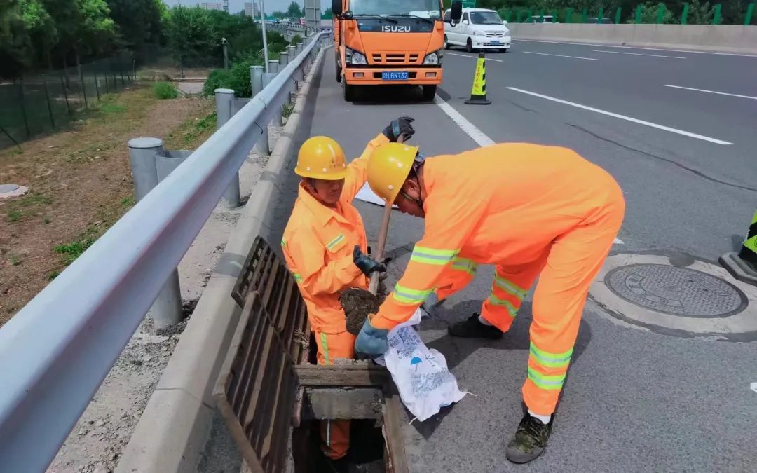 ▲工作人员提前清理高速公路上的排水沟,确保降雨时排水顺畅。首发养护供图