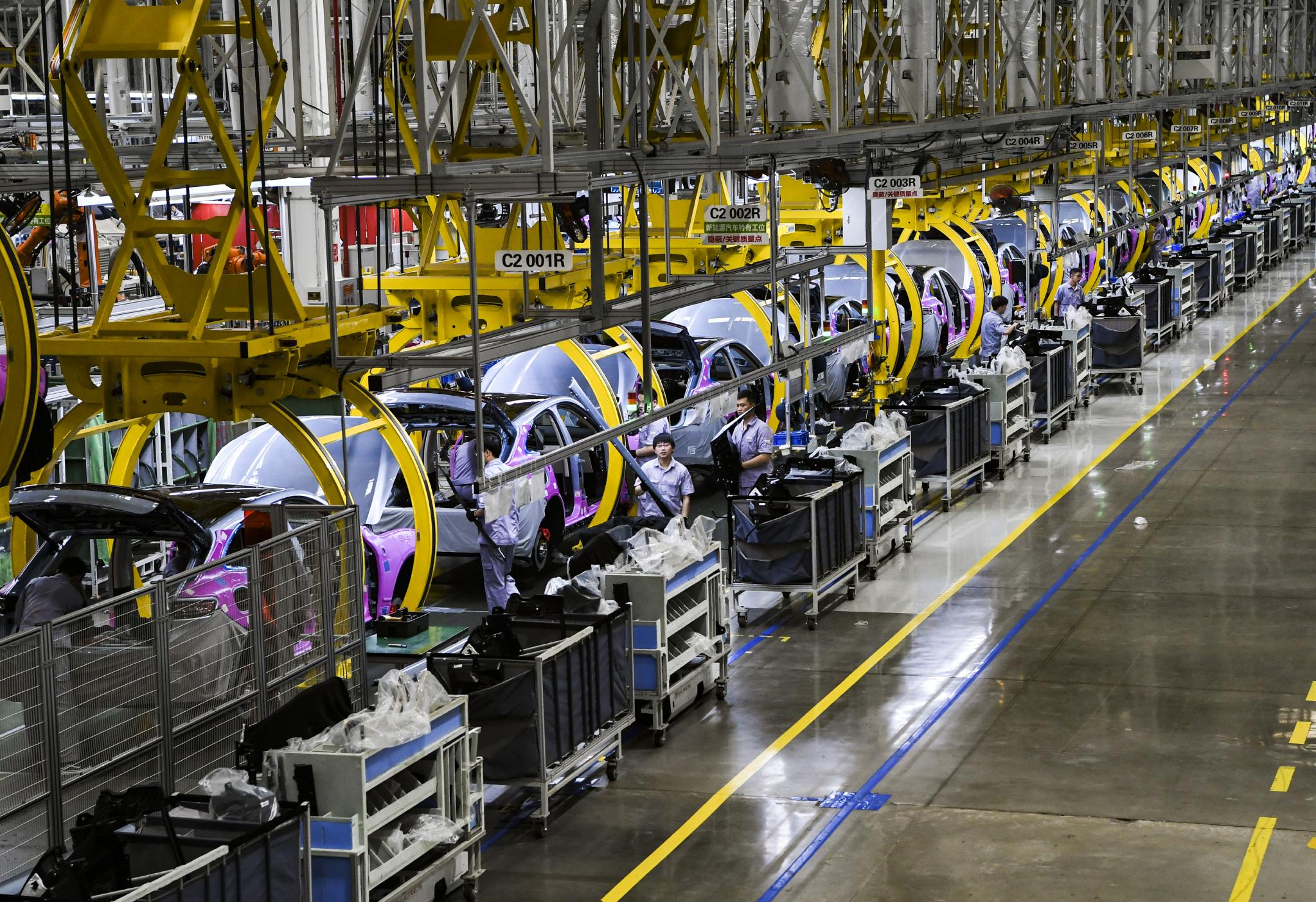 摄6月27日,赛力斯汽车有限公司两江智慧工厂工作人员在生产车间内作业