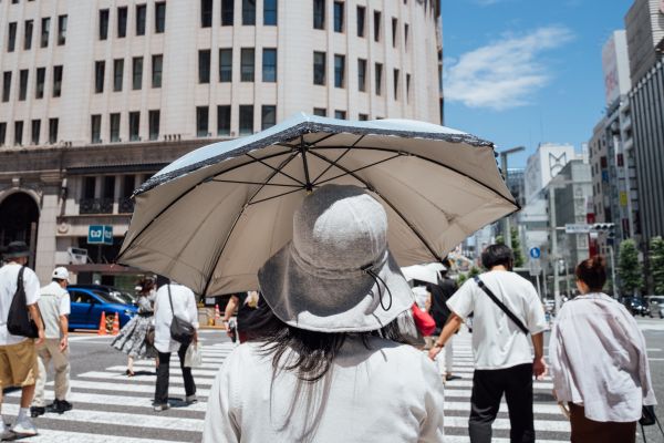 6月26日，行人打着遮阳伞走过日本东京银座街头。新华社