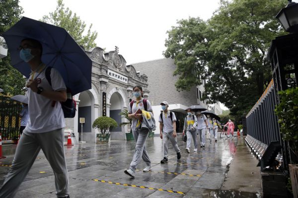 6月27日，北京二中学生在出示健康码、接受体温检测后按照指定通道进入校园。（新华社发）