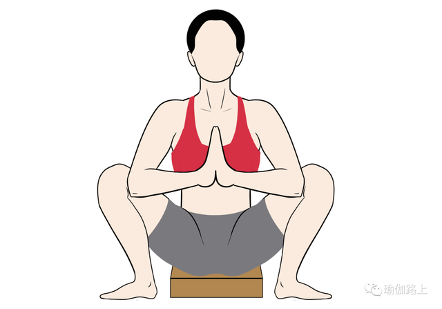 双脚外八张开蹲姿瑜伽砖垫在臀部下方手肘支撑在两膝盖内侧,背部挺直