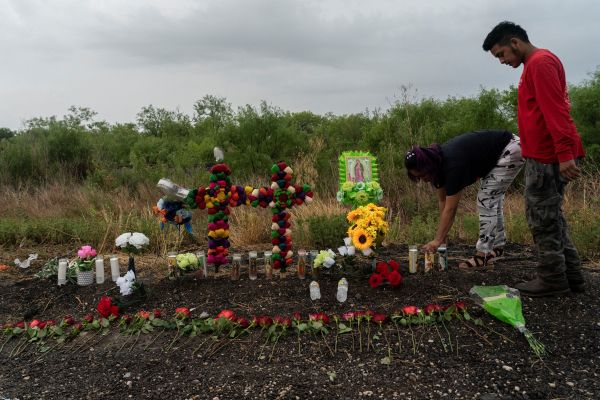 28日，美国得州圣安东尼奥居民在发生移民惨案的现场摆放花束、蜡烛悼念遇难者。（路透社）