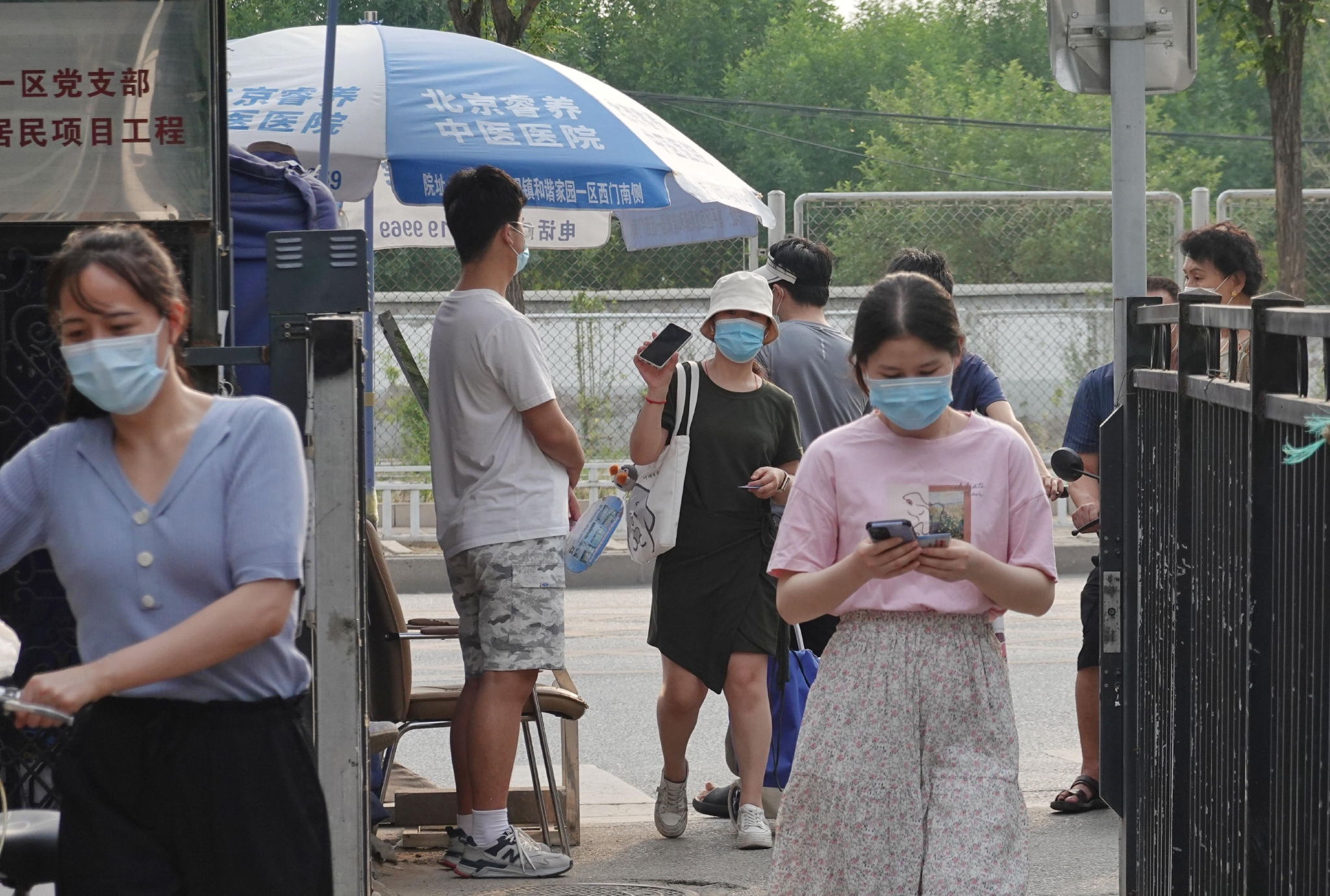 ▲北京昌平区霍营街道龙锦苑东一区社区，居民在小区入口扫码测温，出示健康宝。新京报记者 李木易 摄