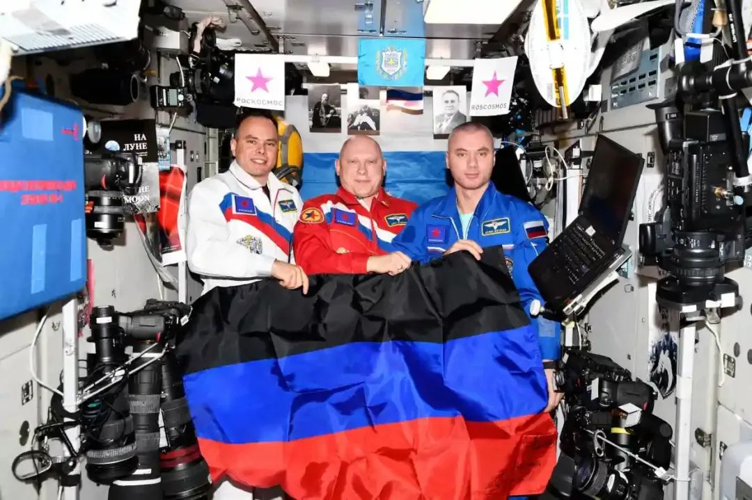 《卫报》称，从配图中可以看到，3名身处国际空间站的俄罗斯宇航员微笑着拿着代表顿涅茨克的旗帜