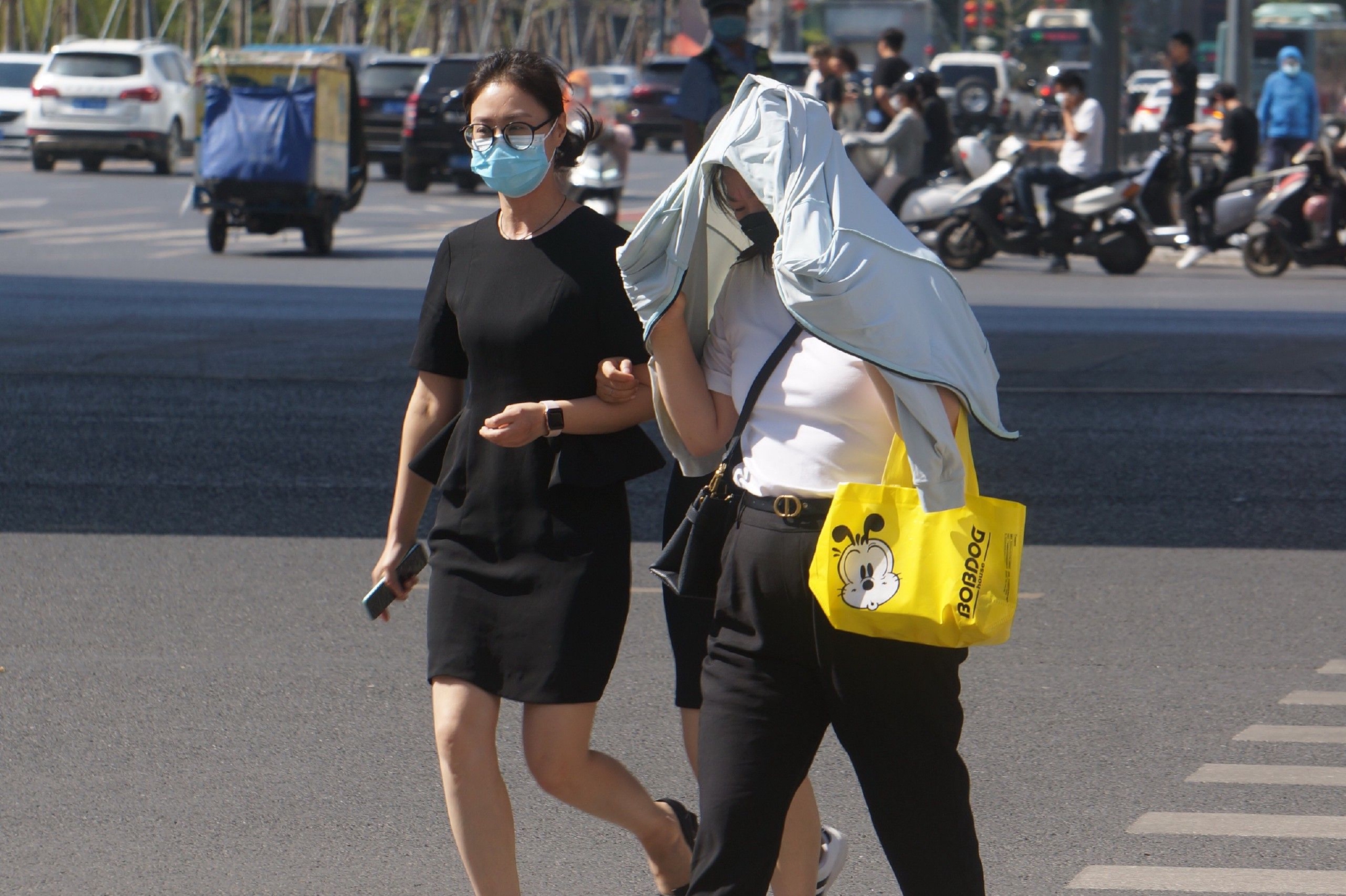 6月17日,河南郑州,出行市民用衣物遮阳,超40℃高温持续在河南多地上演