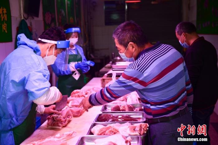 资料图：上海崇明，居民在庙镇集贸市场购买猪肉。 中新社记者 田雨昊 摄