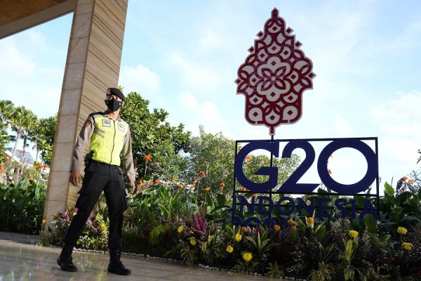 图片说明：7日，一名印尼警察走过在巴厘岛的G20外长会议会场的标识牌。（美联社）
