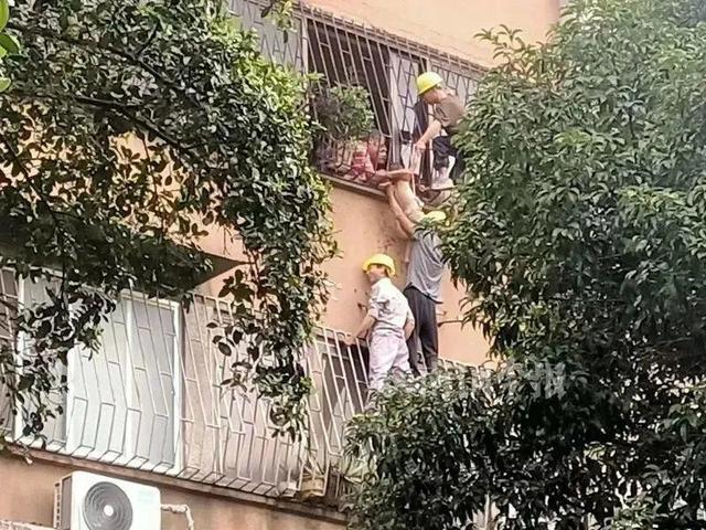 惊险！2岁幼童被卡防盗网，三名工人徒手爬楼施救