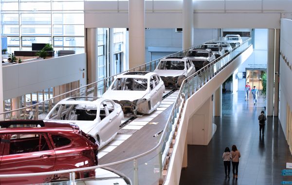 2022年2月16日，在华晨宝马沈阳铁西工厂，生产中的车辆穿过办公区。（新华社发）