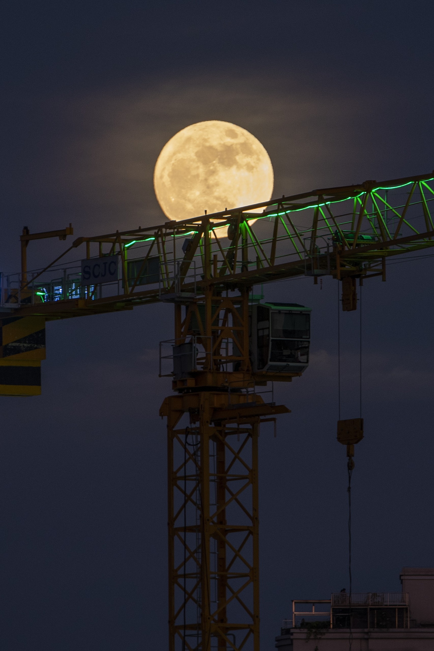 2022年7月13日,一轮明月挂在深圳夜空下的吊车上.