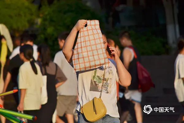 △7月11日,重庆最高气温达到40.2℃,市民高温下出行。(图/曹凯)