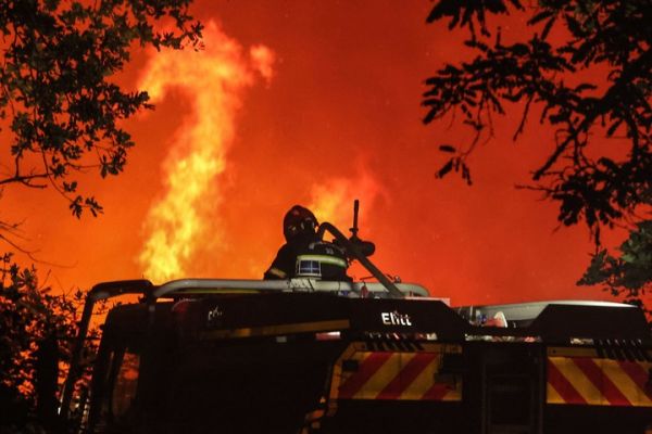 13日，法国西南部发生火灾，消防队员试图控制蔓延的森林大火。（法新社）