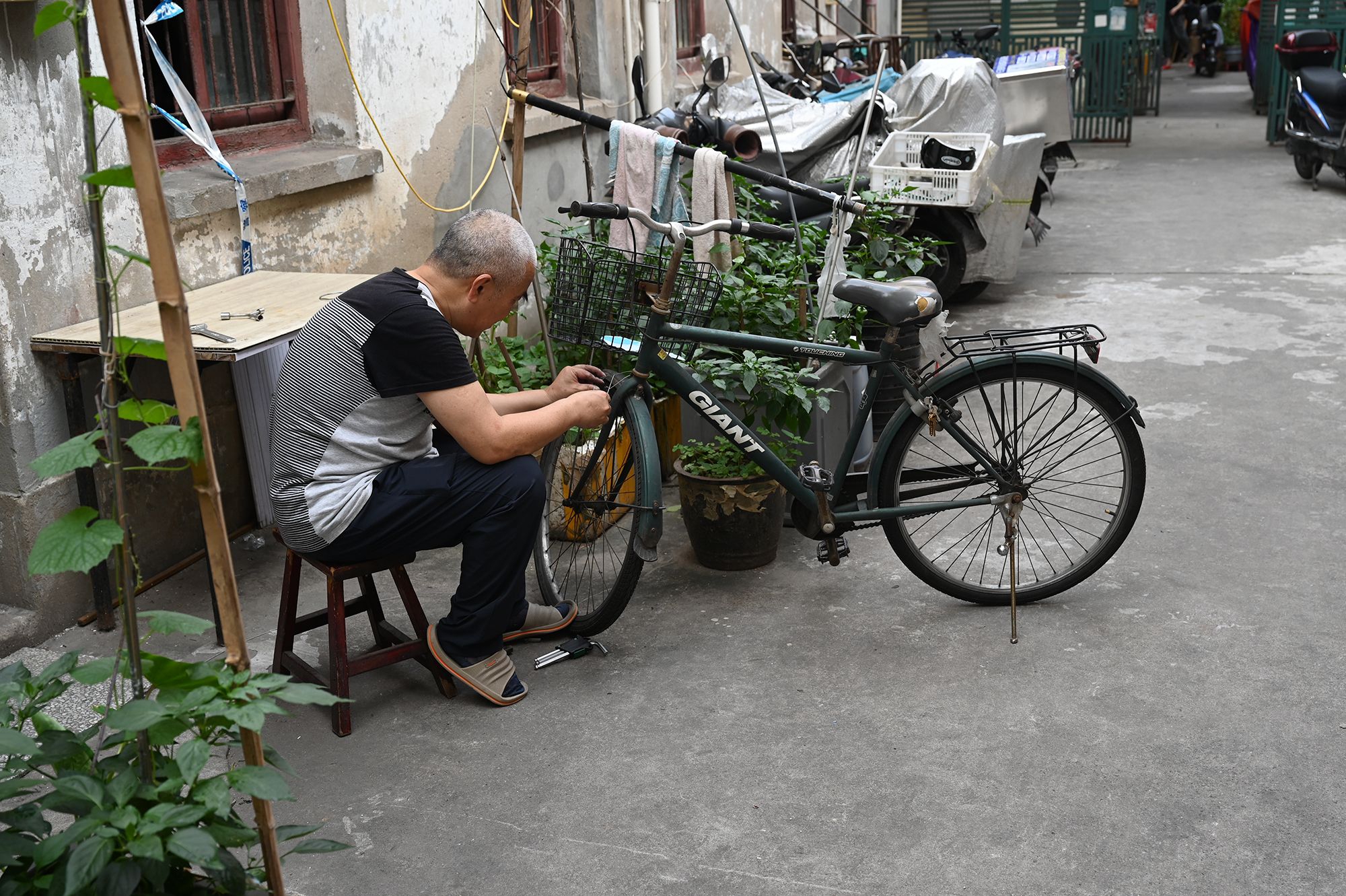 2022年7月3日,上海市黄浦区,广东路,正在修车的当地居民.