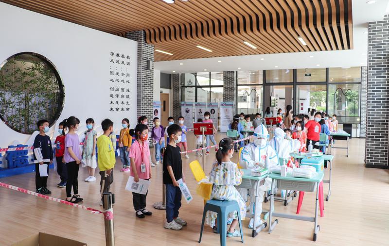 禅城区东华里小学核酸检测现场,医护人员正在为孩子们进行采样工作.