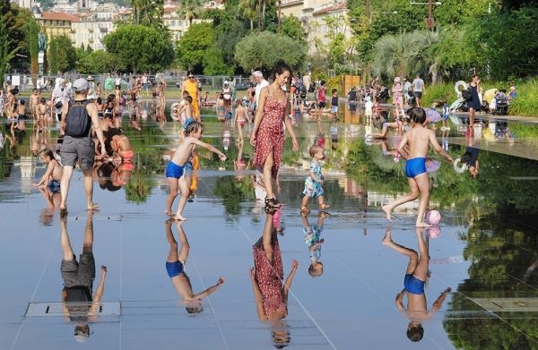 7月13日，人们在法国尼斯一处喷泉消暑。（新华社）