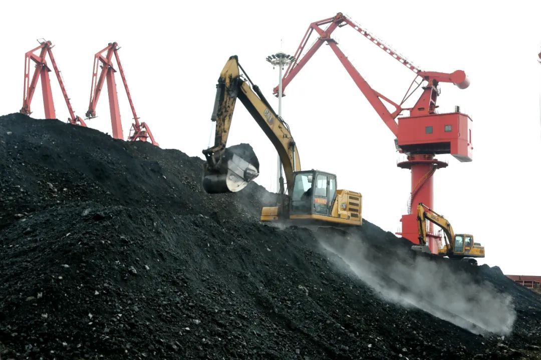 在江苏省连云港港煤炭码头,大型机械正在堆放从货轮卸下的电煤.