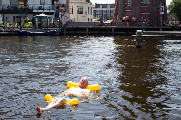 7月19日，在荷兰哈勒姆，一名男子躺在水中消暑（新华社发）