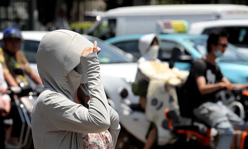 7月15日，昆明市，中午时分，烈日炎炎，户外紫外线强烈，出行市民纷纷开启防晒模式。视觉中国 图