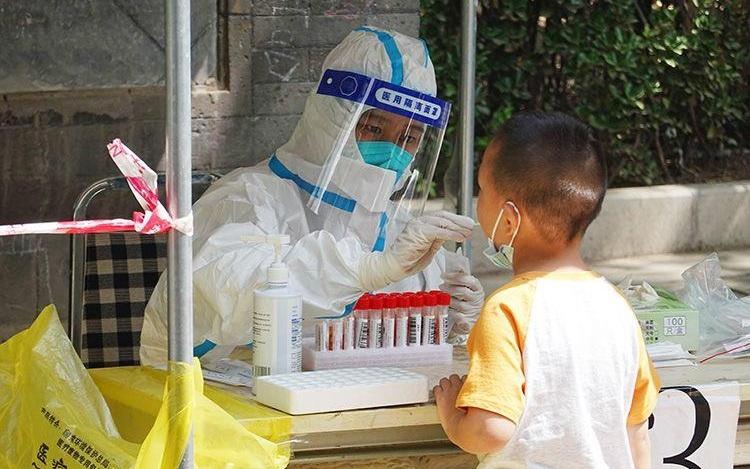 ▲资料图：核酸采集人员正在为一名小朋友采集咽拭子。新京报记者 李木易 摄