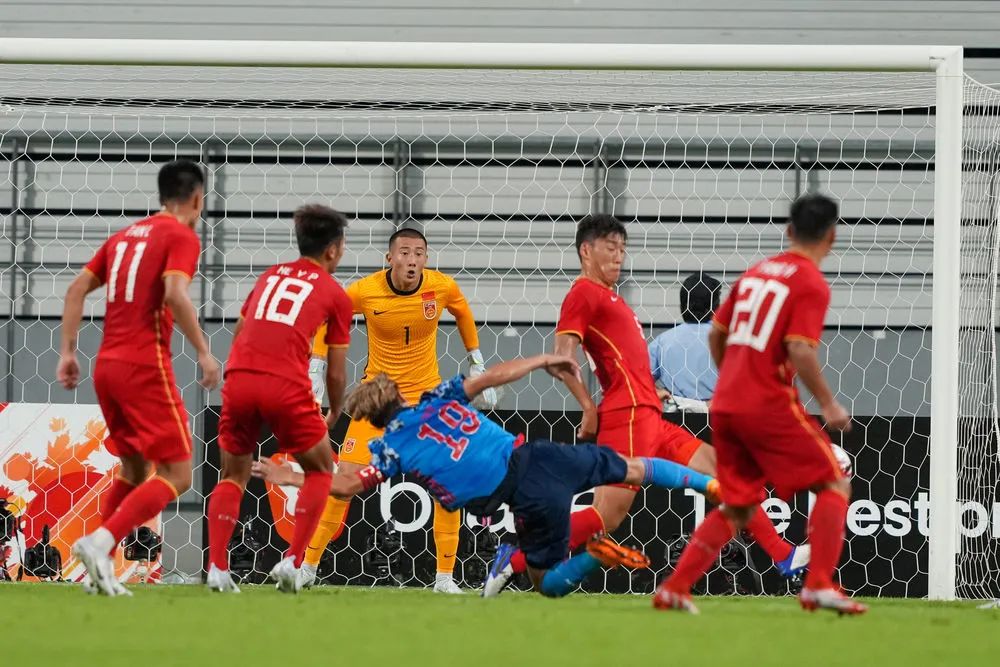 ▲中国男足选拔队守门员韩佳奇（后中）在比赛中防守日本队球员佐佐木翔（前中）的射门。