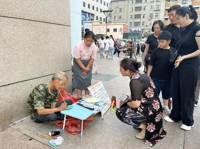 日照老人青岛街头卖字筹钱，多位热心市民伸援手，他含泪写下“感恩青岛”