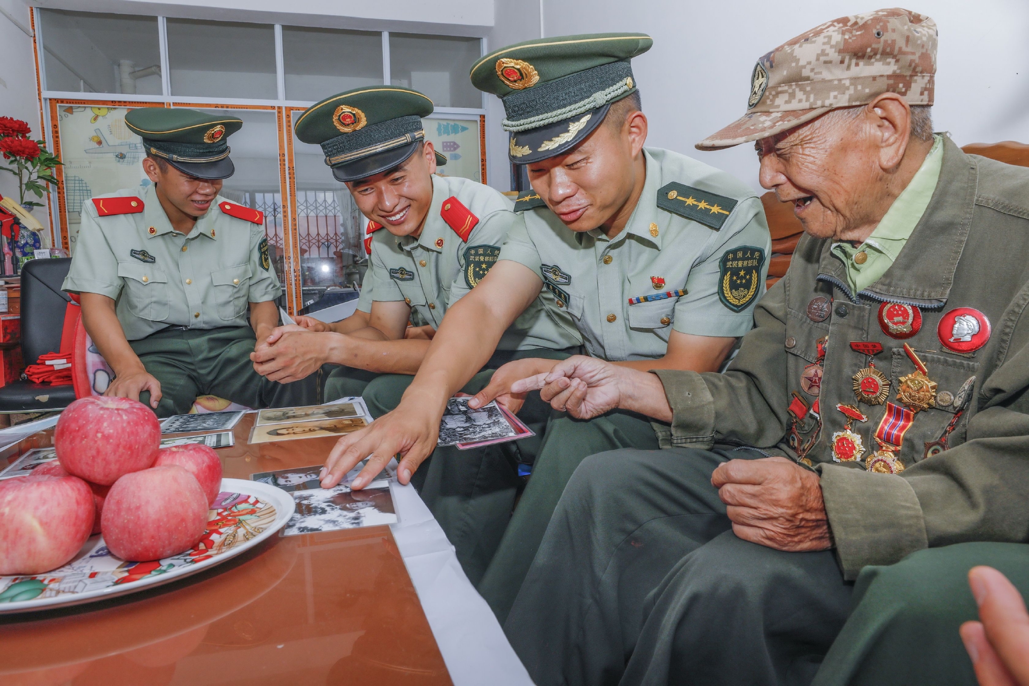 武警官兵正在观看老兵李渭清以前的老照片.施晨洲 摄