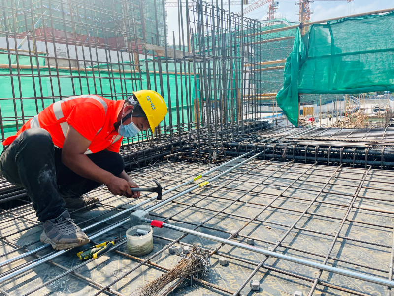 通訊員 元大端)扎絲,綁筋,固牢……在建築工地上的夏師傅蹲在鋼筋作業