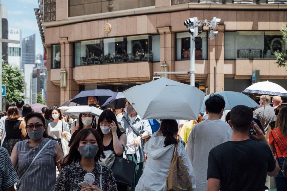 6月26日,行人打着遮阳伞走过日本东京银座街头.新华社记者张笑宇摄