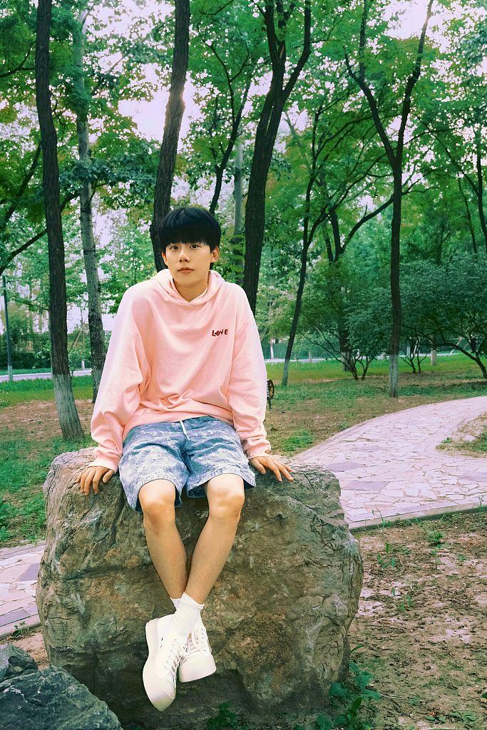 周奇发布一组周末随拍写真穿糖果色卫衣漫步林间