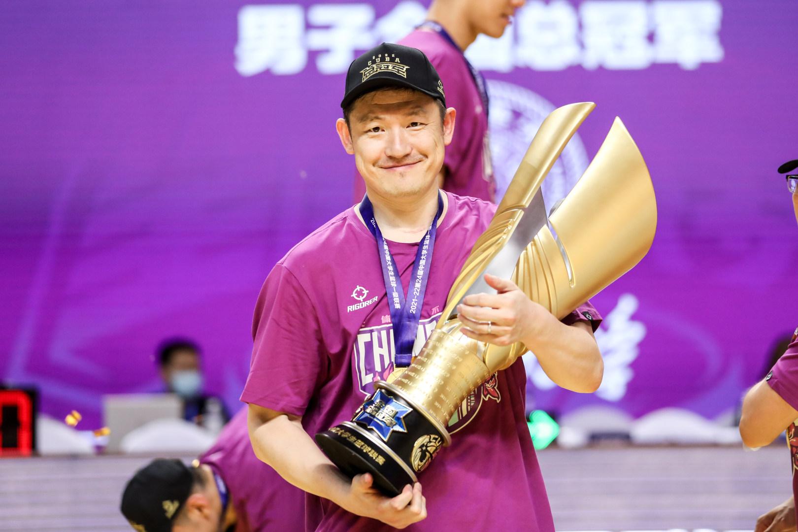 清华大学男篮主教练陈磊怀抱冠军奖杯.