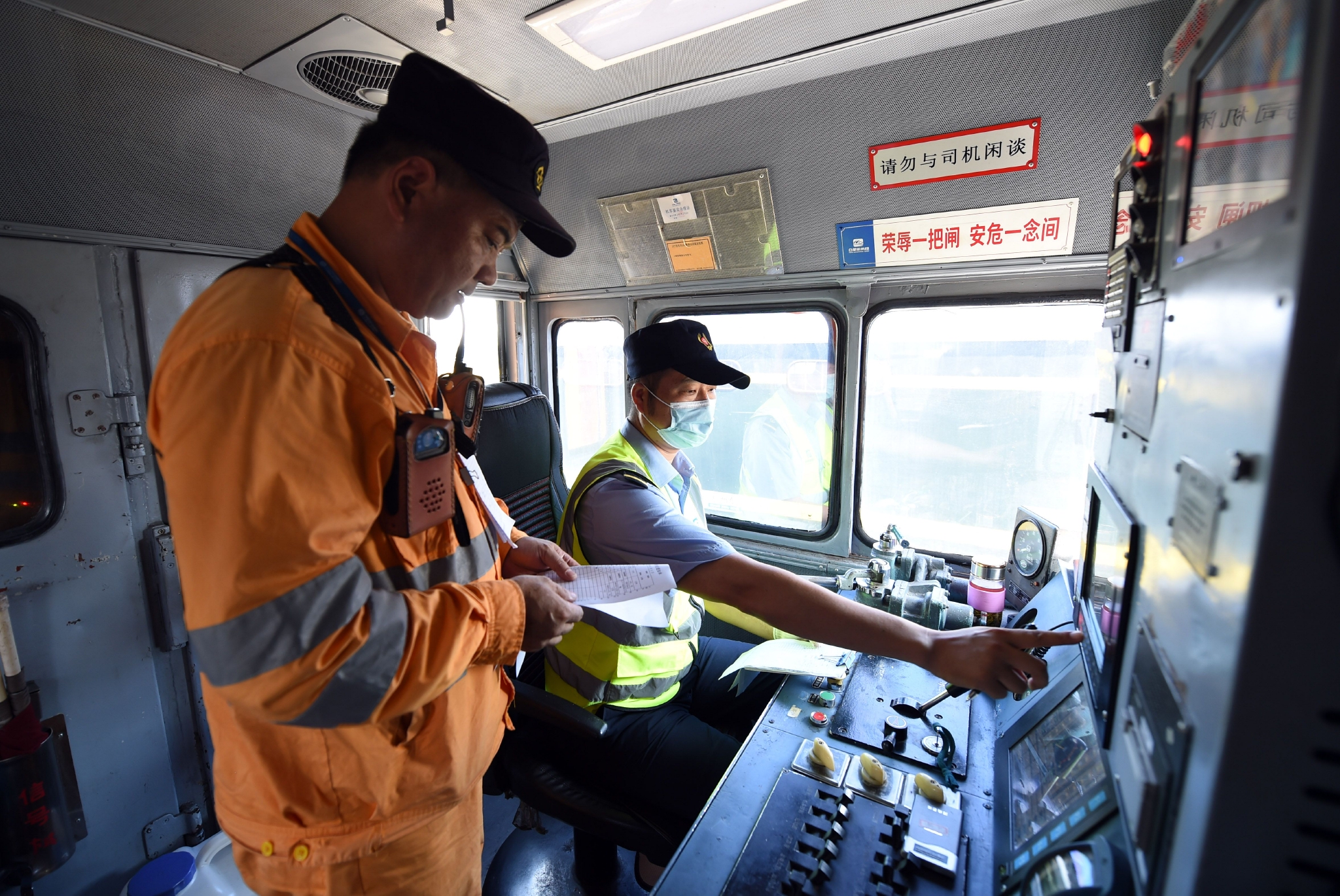 8月5日,合肥火车站运转车间调车长李健(左)和调车机车司机确认调车