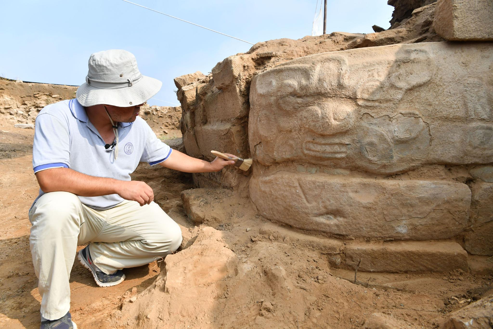考古工作者正在对石雕进行发掘清理。新华社记者张博文摄
