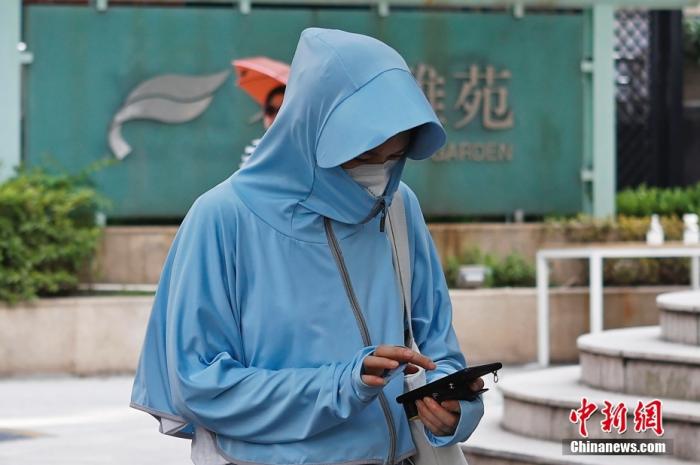 资料图：出行市民包裹严实防晒防暑。 中新社记者 殷立勤 摄