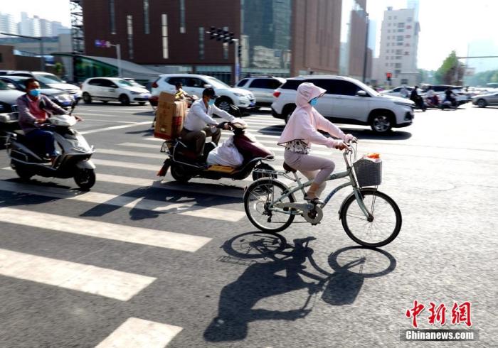 资料图：河南郑州，出行民众“全副武装”遮阳防晒。 中新社记者 王中举 摄