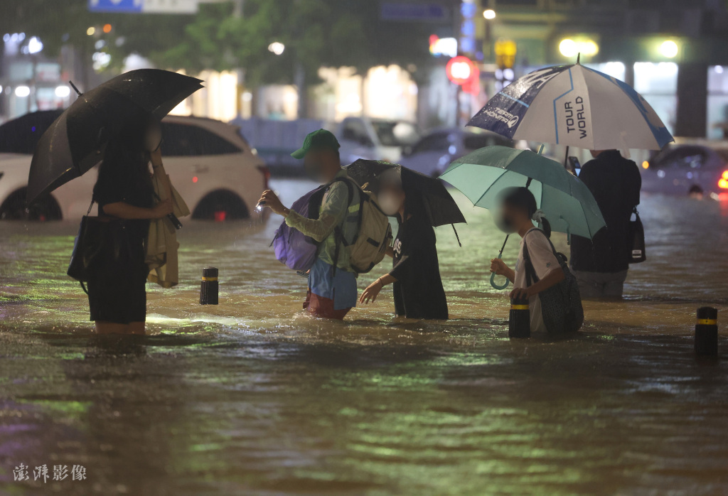 首尔市民在积水中行进