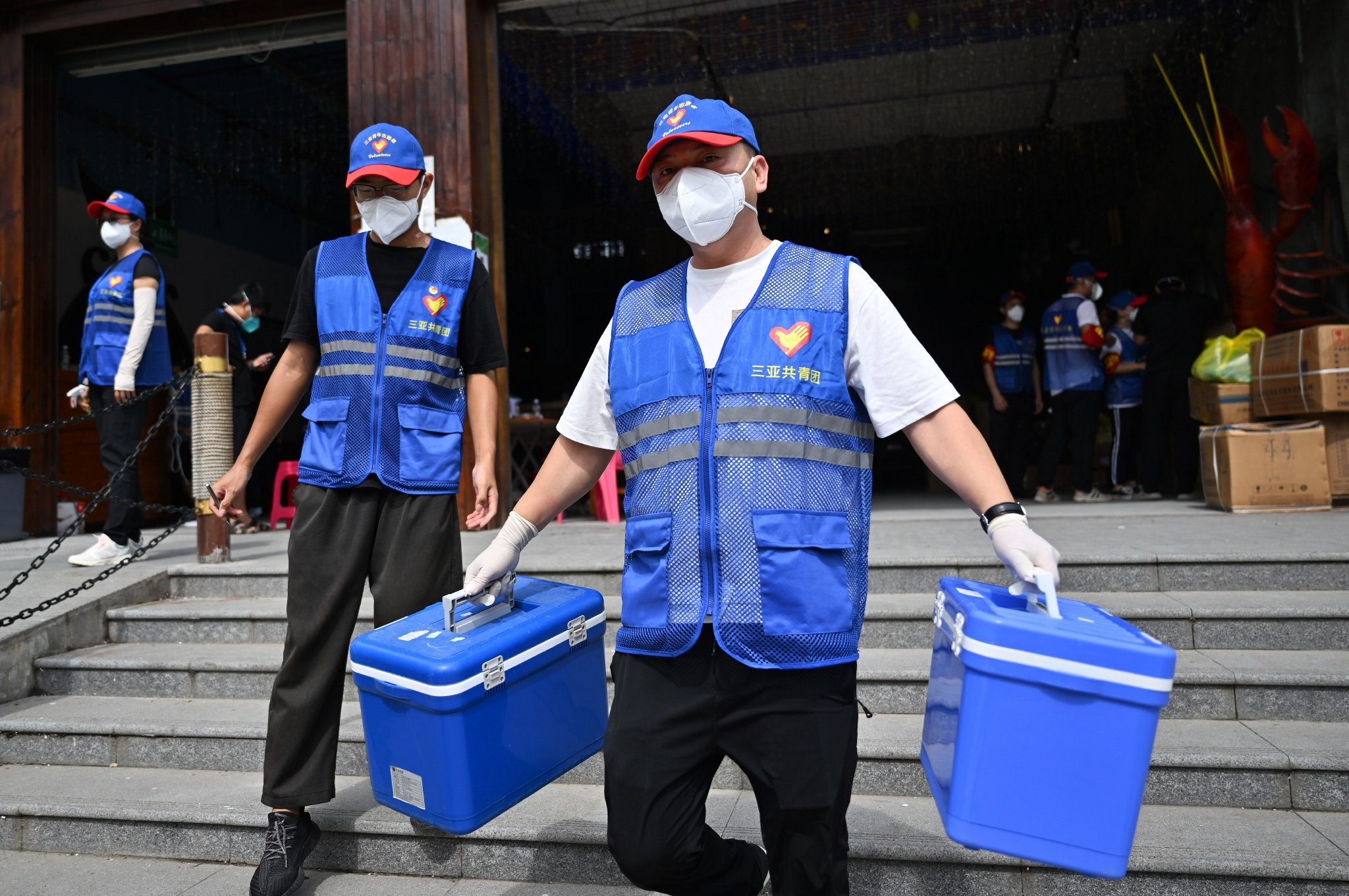 来自浙江温州的游客陈义穿着蓝马甲,和其他志愿者一起忙着搬运医疗