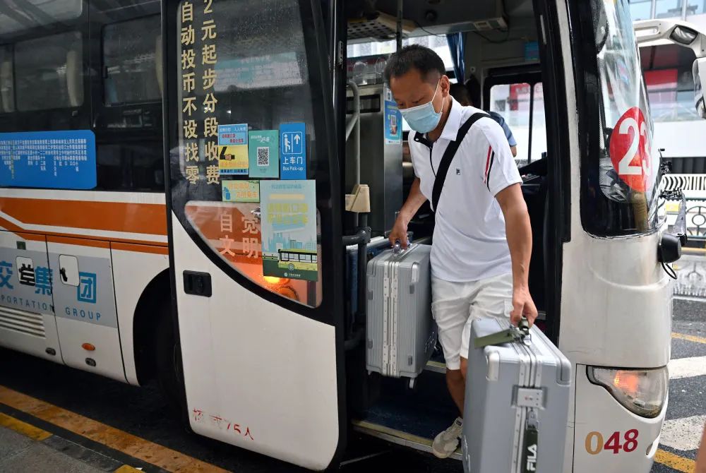 8月9日,滞留三亚的游客走下大巴,准备进入三亚凤凰国际机场(郭程/摄)