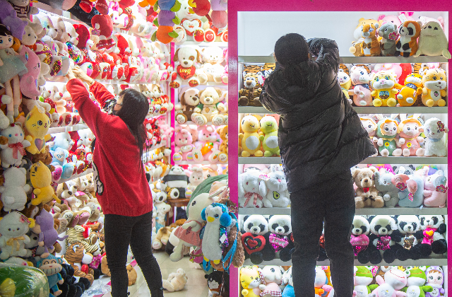2022年2月12日,义乌中国小商品城开市营业,经营户在整理货架。新华社图
