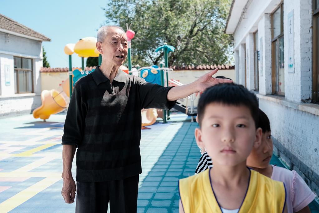 吴富生带孩子们排队。（采访对象供图）