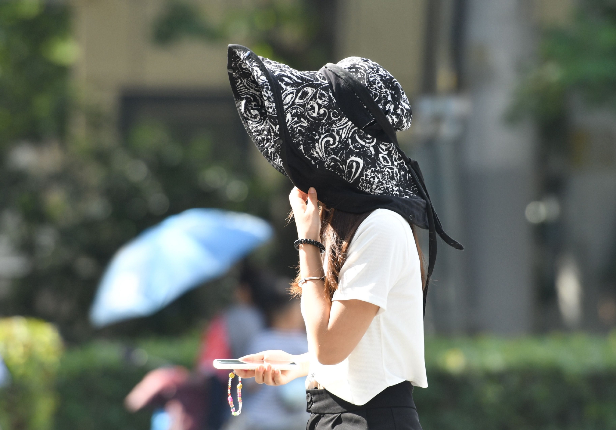 8月13日，安徽阜阳，当地高温天气持续，出行的市民采取各种方式抵御热浪。图/IC photo