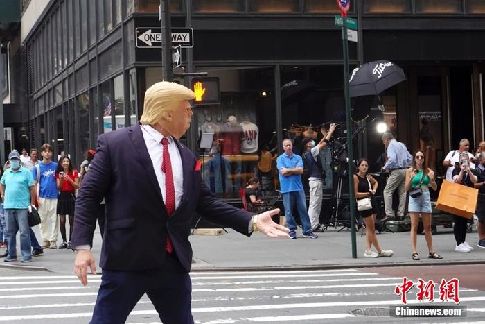 资料图：当地时间2022年8月10日，一名戴着面具的示威者在美国纽约特朗普大厦外模仿特朗普。近两日，特朗普大厦前示威者、记者、围观民众等人流聚集。 中新社记者 廖攀 摄