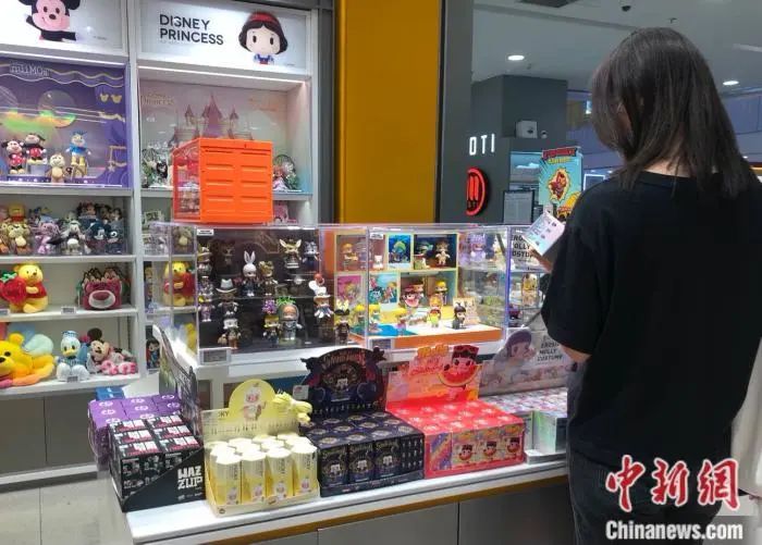 资料图：消费者在泡泡玛特门店挑选Molly盲盒。中新网 左宇坤 摄