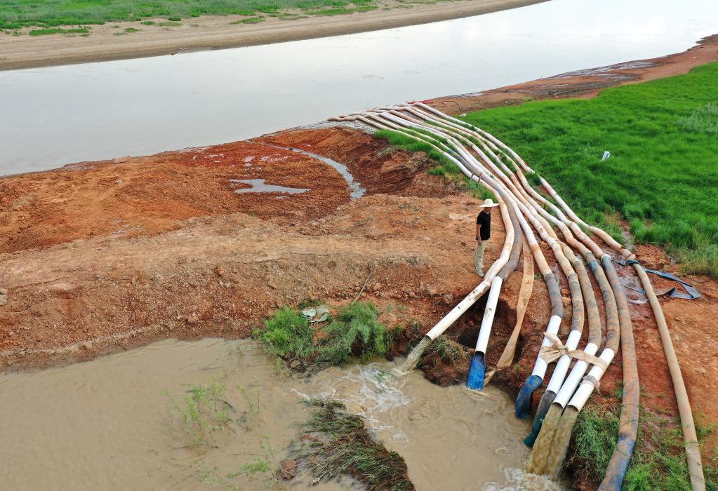 都昌县周溪镇枭阳圩堤外,当地用8台抽水机将水从河道抽到渠内.