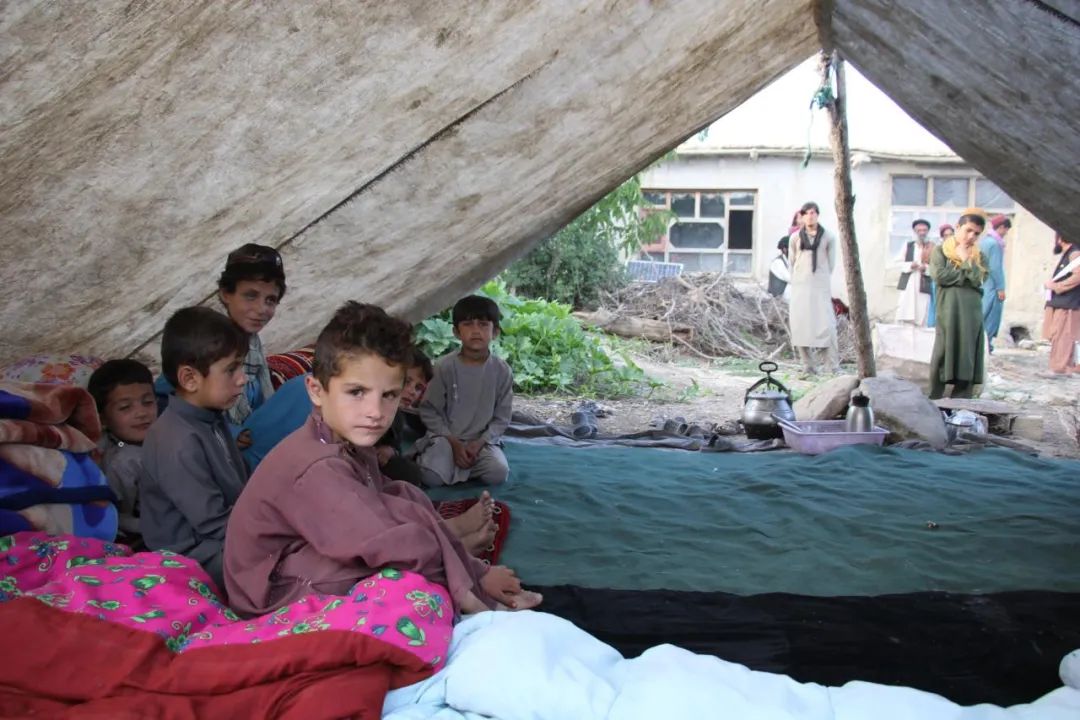 7月18日,在阿富汗帕克提卡省受灾地区,儿童坐在帐篷里.