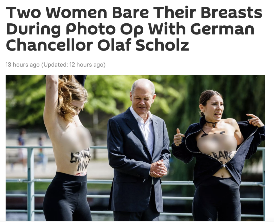 女子与德国总理合影时突然赤裸上身 要求禁运天然气