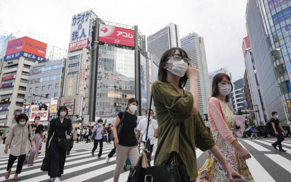 7月28日，戴口罩的行人走在日本东京街头。（新华社发）