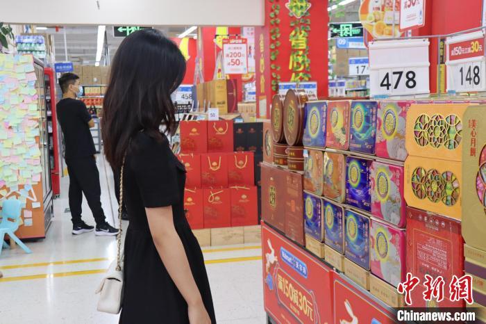 图为今年中秋前市民在超市选购月饼礼盒。　唐诗 摄