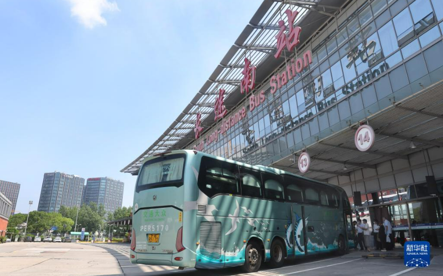 7月5日,在上海长途客运南站,一辆客车停靠在检票口外等待旅客登车.